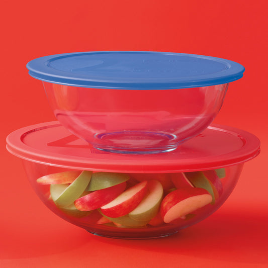 Stack of glass bowls with colorful fruit slices on a red background