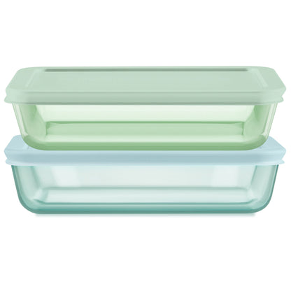 Two glass food storage containers with green and blue lids on a white background