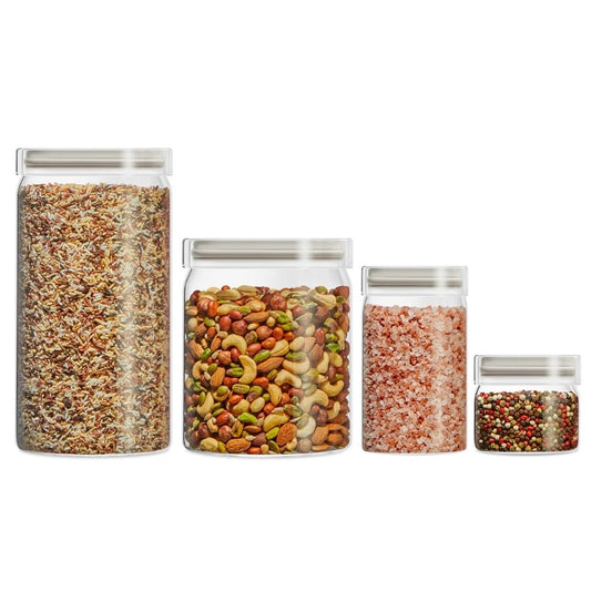 Set of four glass jars with lids, each containing different types of food on a white background