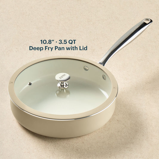 Deep fry pan with lid on a beige background