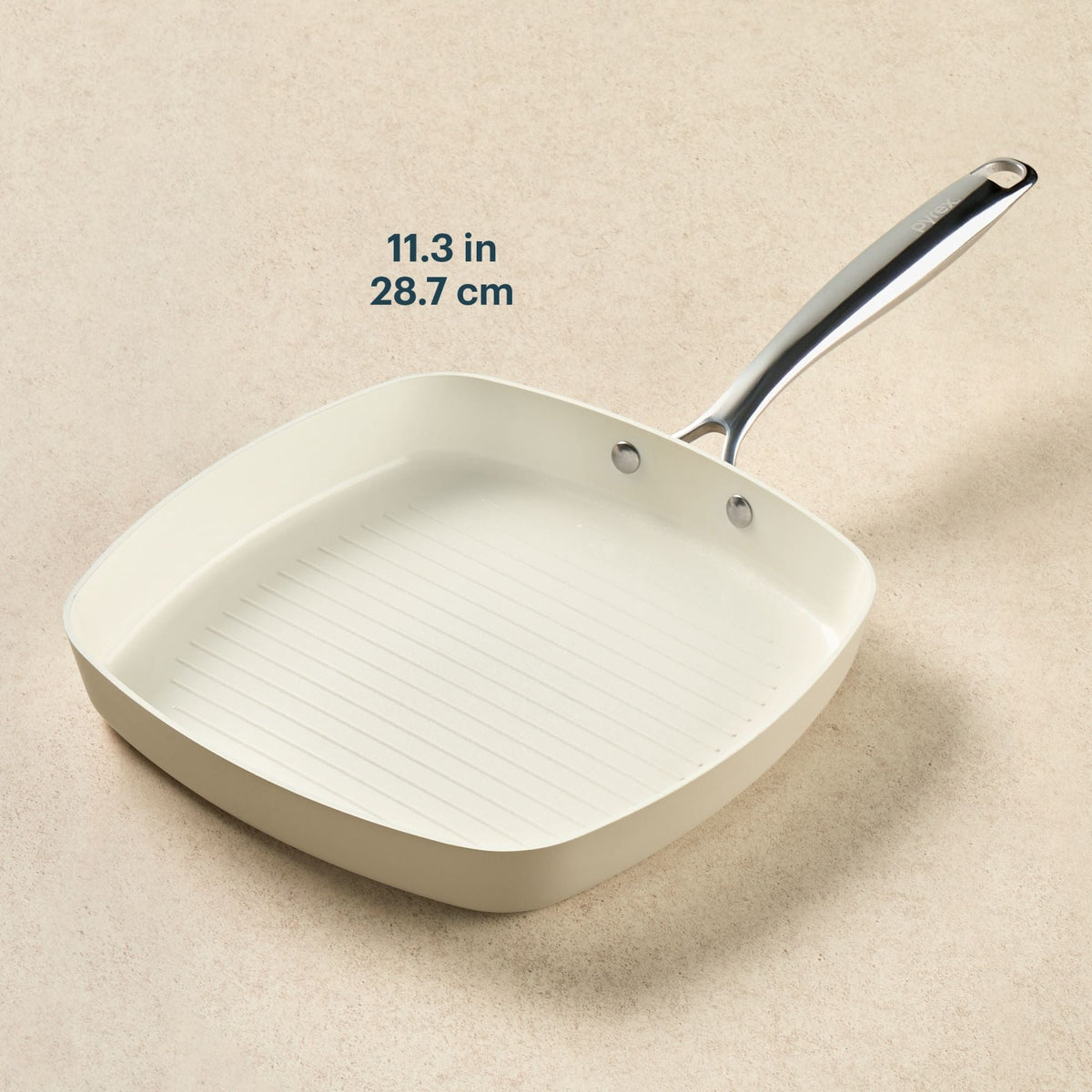 White square frying pan with measurement text on a beige background