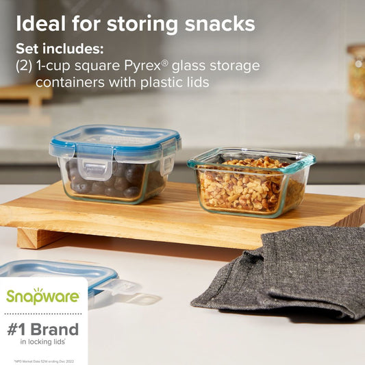 Pyrex glass storage containers with plastic lids on a wooden surface, featuring Snapware branding.
